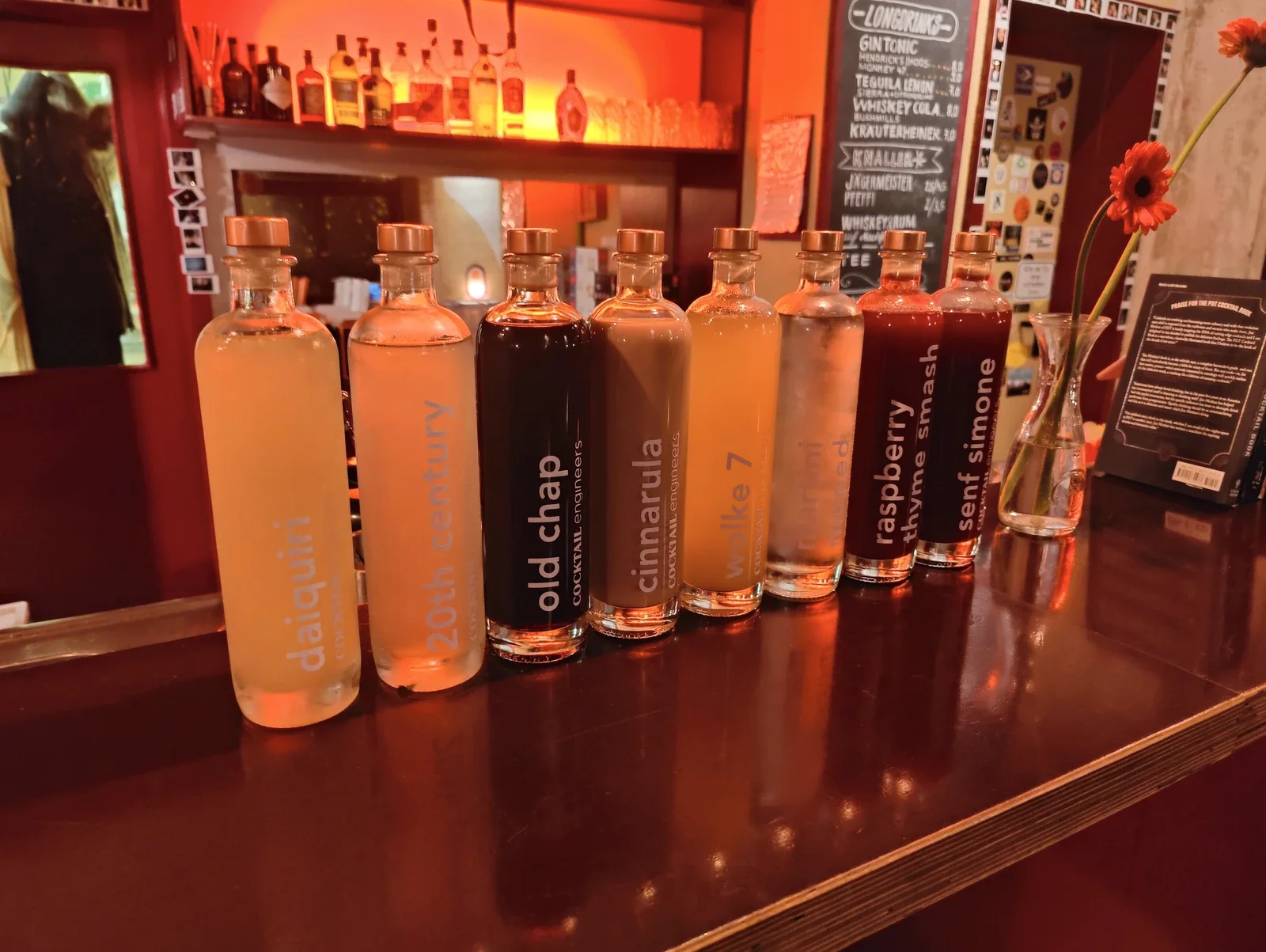 Die Cocktail-Engineers-Auswahl: acht unterschiedliche abgefüllte Cocktails nebeneinander auf dem Bartresen.